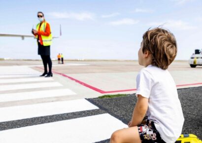A young passenger sits on a Trunki suitcase on the tarmac at Avalon, Melbourne airport's curfew-free international gateway, as ground crew prepare for departure