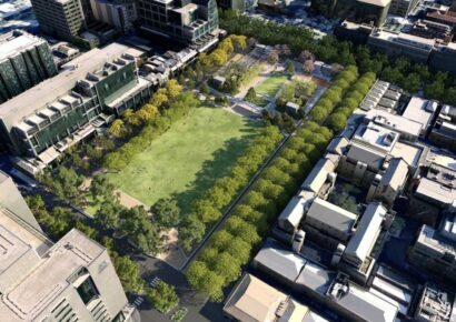 Aerial render of the redeveloped University Square in Carlton, showing an expanded green lawn surrounded by mature trees and university buildings, part of the Metro Tunnel Parkville Station precinct.