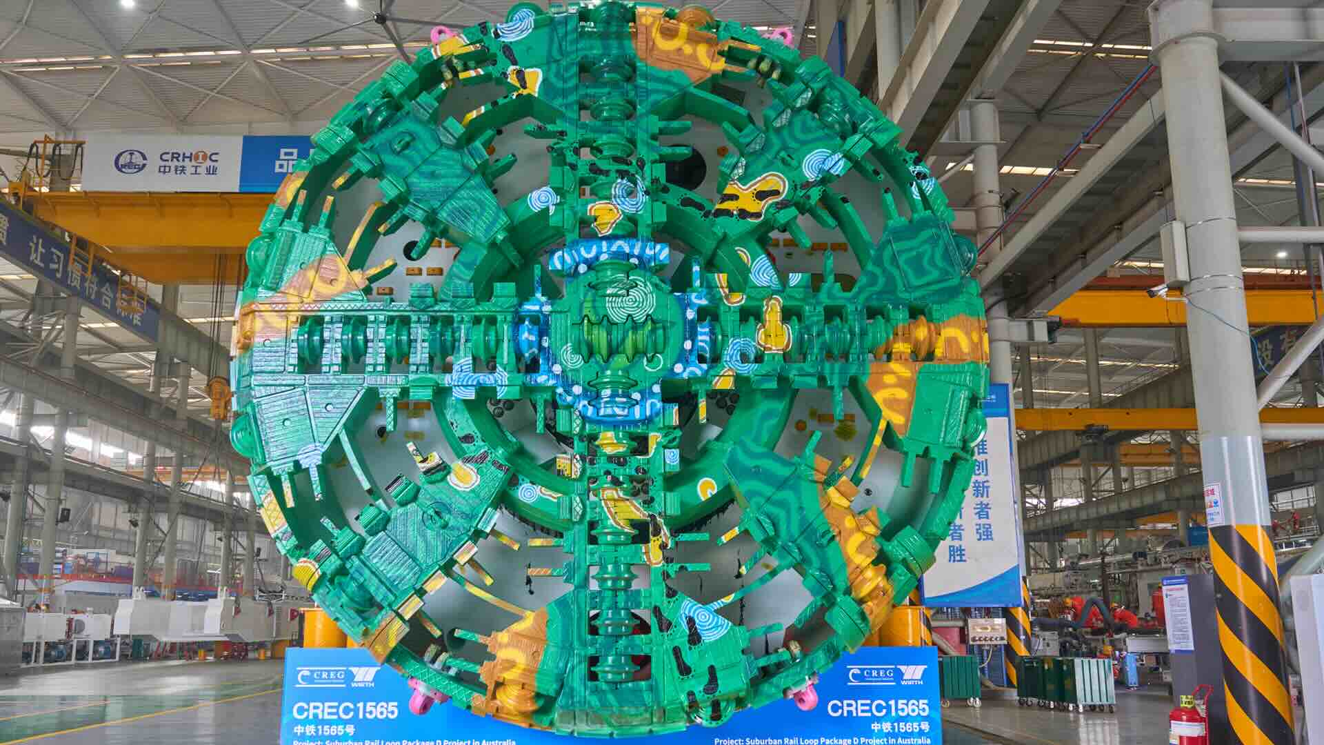 Suburban Rail Loop tunnel boring machine cutterhead featuring Wurundjeri artist Hayden Roberts' Footsteps of the Past artwork, photographed at the CREG manufacturing facility in Zhengzhou