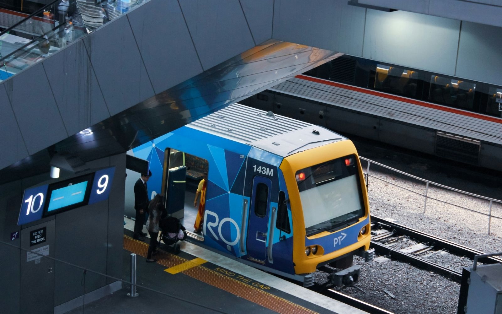 Alt text: A Melbourne trains Metro service at the platform as passengers board