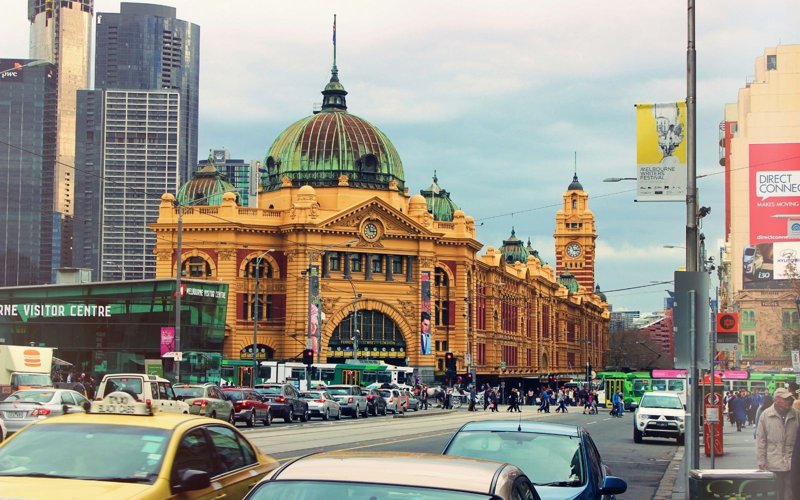 Alt text: Flinders Street Station in Melbourne with trams and traffic on the surrounding streets