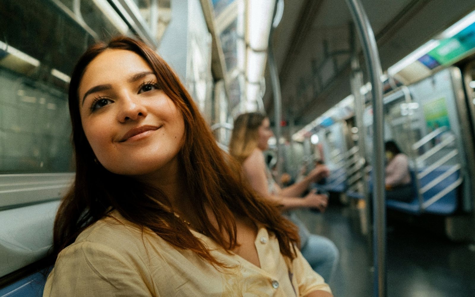 Alt text: A commuter smiles while riding Melbourne trains during free public transport