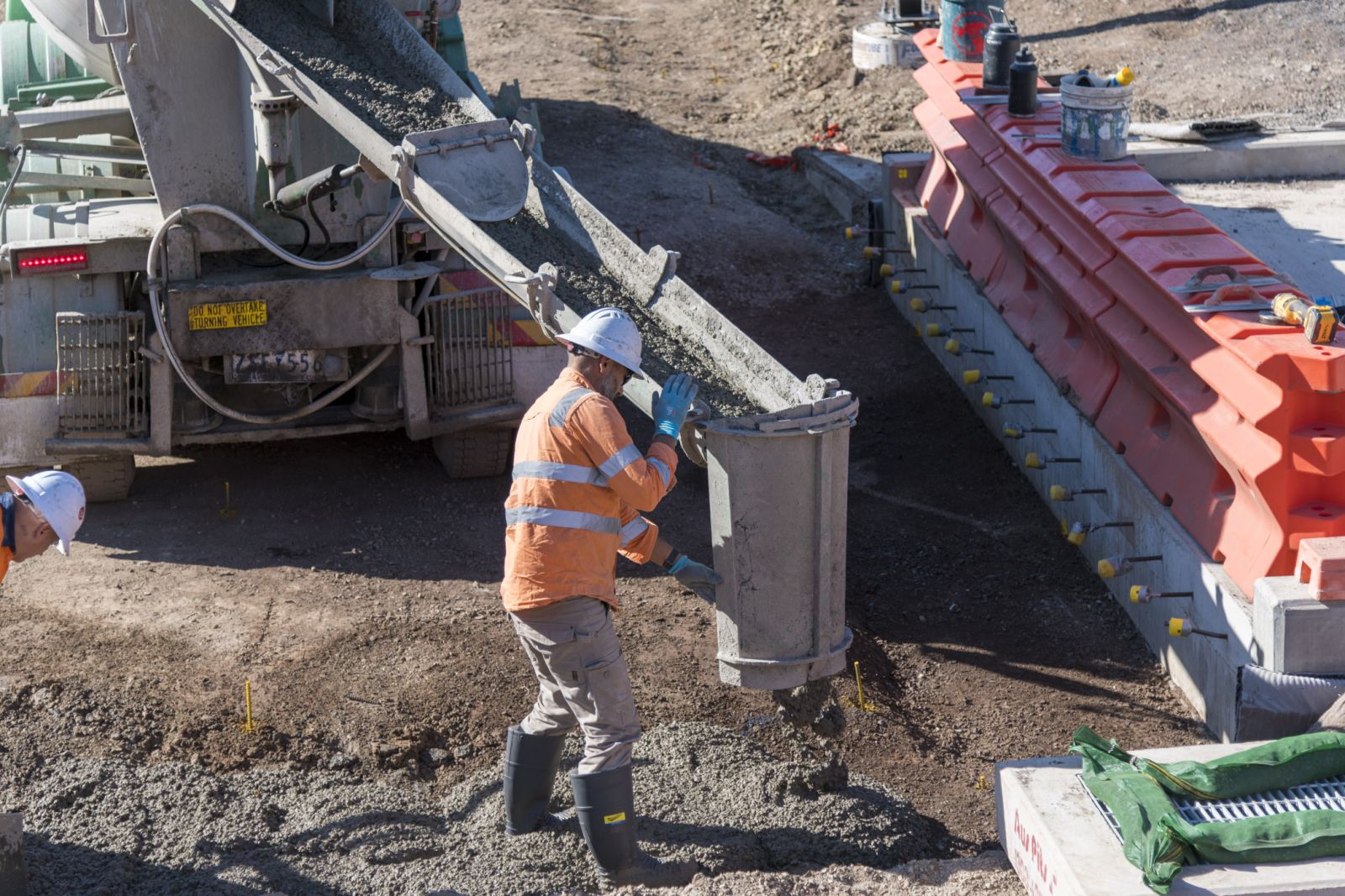 A concrete agitator truck delivers to workers building ramps at the new Melbourne train station at West Tarneit.