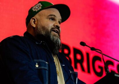 Briggs in front of a pink background, campaigning for greater music funding this Victorian election.